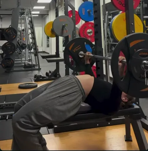 Athlete benching in training with a spotter