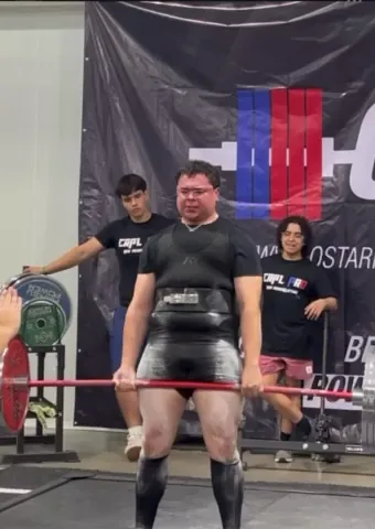 Athlete finishing a deadlift in front of the CRPL backdrop