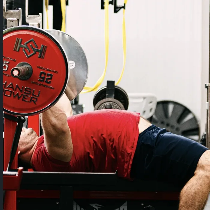 Douglas Lutz pressing at the bench with competition plates loaded